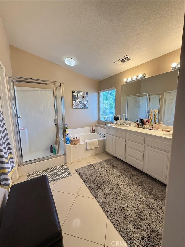 bathroom featuring a textured ceiling, vaulted ceiling, tile patterned flooring, independent shower and bath, and vanity