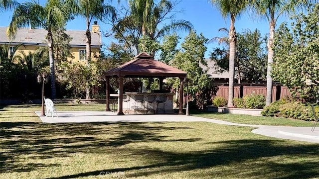 view of community featuring exterior bar, a yard, and a gazebo