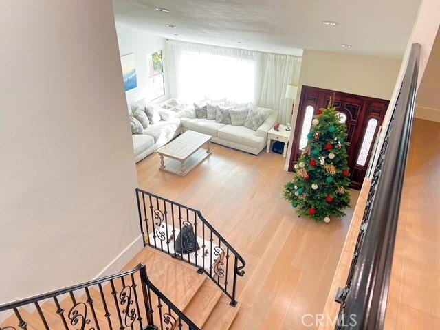 living area with stairs, baseboards, and wood finished floors
