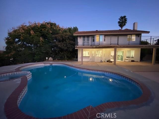 pool at dusk with a patio