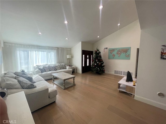 living room with vaulted ceiling and light hardwood / wood-style flooring