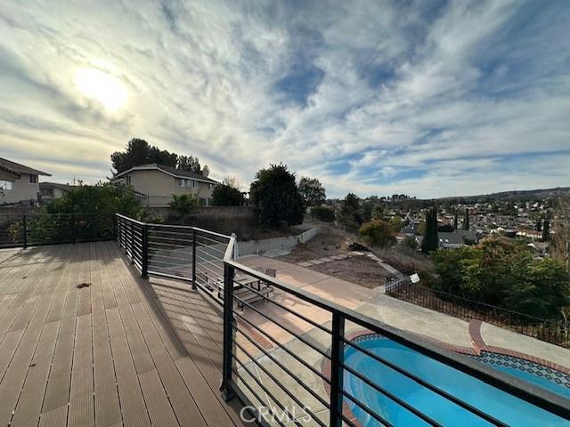 wooden terrace featuring a fenced in pool