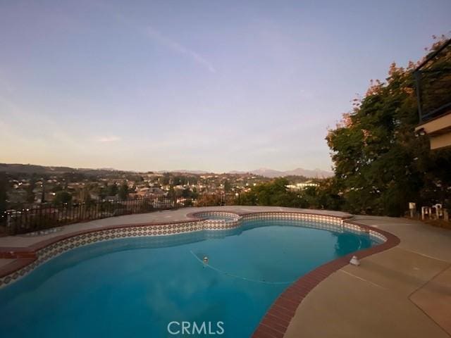 pool featuring a patio and an in ground hot tub