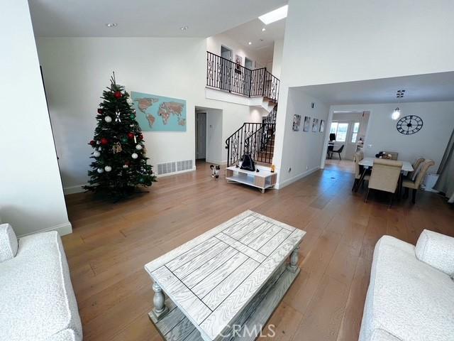 living room featuring hardwood / wood-style flooring and a towering ceiling