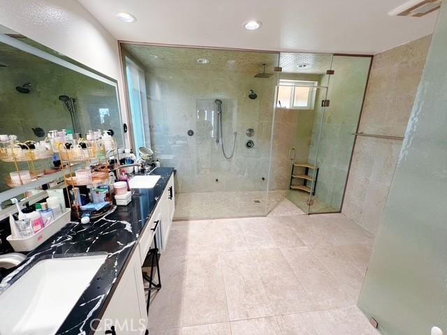 bathroom featuring a tile shower and vanity