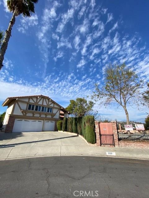 view of front of property featuring concrete driveway, stucco siding, fence, and an attached garage