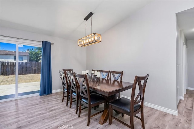 dining space featuring light hardwood / wood-style floors and a notable chandelier