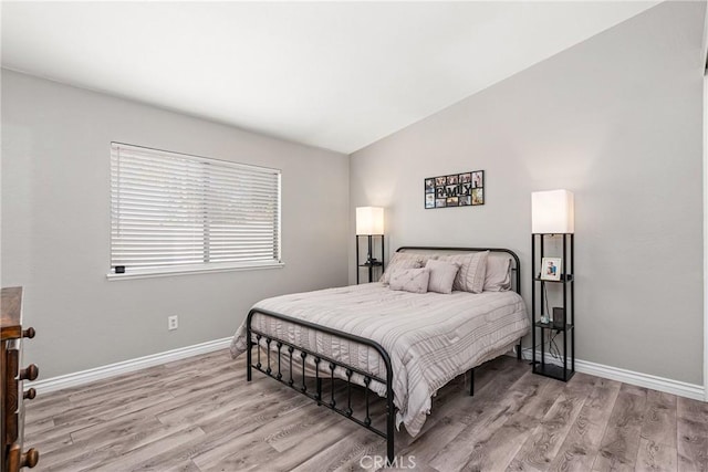 bedroom featuring vaulted ceiling and light hardwood / wood-style flooring