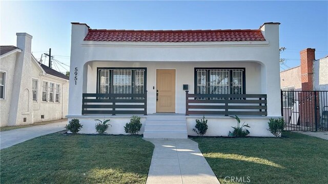 mediterranean / spanish-style house featuring a porch and a front lawn