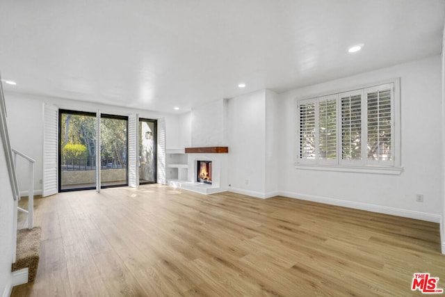 unfurnished living room featuring light hardwood / wood-style floors and a healthy amount of sunlight