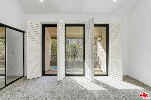 doorway to outside with light carpet