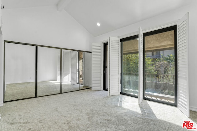 unfurnished bedroom featuring access to outside, a closet, beamed ceiling, and light colored carpet