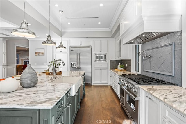 kitchen featuring pendant lighting, sink, built in appliances, light stone countertops, and custom range hood