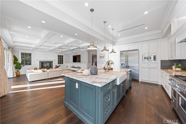 kitchen featuring coffered ceiling, beamed ceiling, built in appliances, pendant lighting, and white cabinets