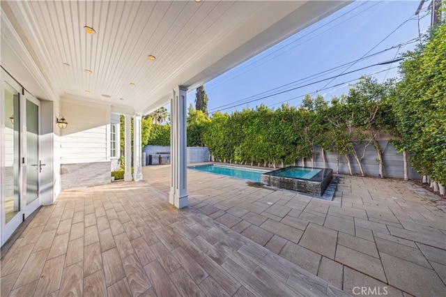 view of pool featuring an in ground hot tub and a patio