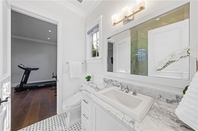 bathroom with toilet, vanity, an enclosed shower, and ornamental molding