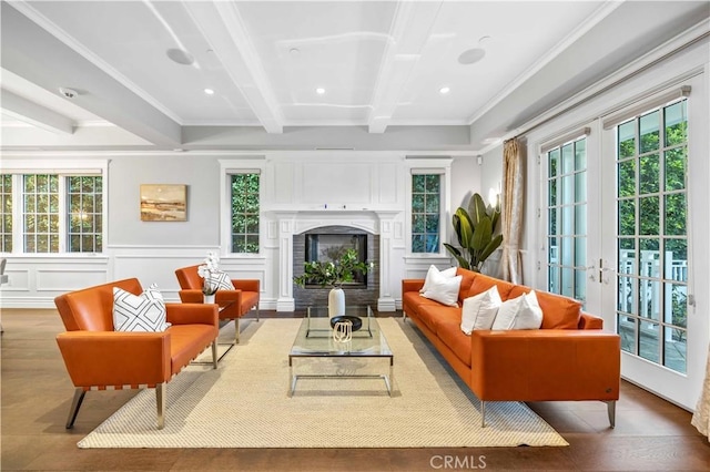 living room with french doors, beamed ceiling, a healthy amount of sunlight, and ornamental molding