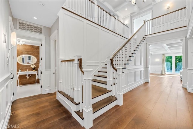 stairway with beamed ceiling, wood-type flooring, and coffered ceiling