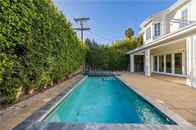 view of swimming pool with an in ground hot tub, french doors, and a patio area