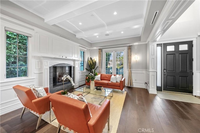 living room with beam ceiling, dark wood-type flooring, and ornamental molding