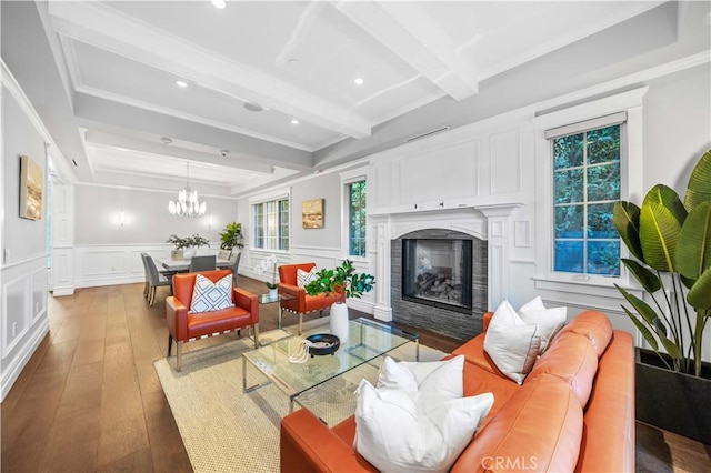 living room featuring beam ceiling, a notable chandelier, and wood-type flooring