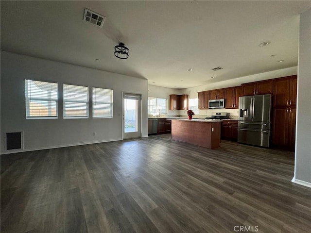 kitchen with appliances with stainless steel finishes, a center island, dark hardwood / wood-style floors, and sink