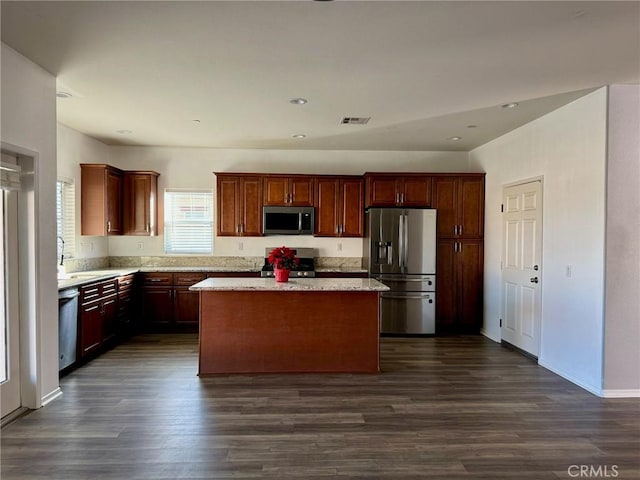 kitchen with sink, a center island, dark hardwood / wood-style flooring, and stainless steel appliances