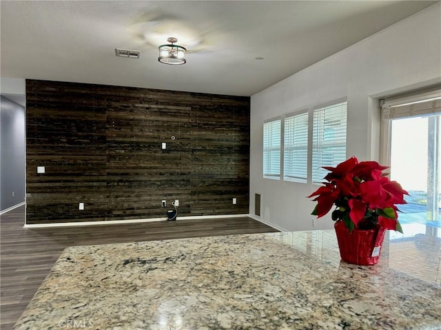 living room with dark wood-type flooring and wood walls