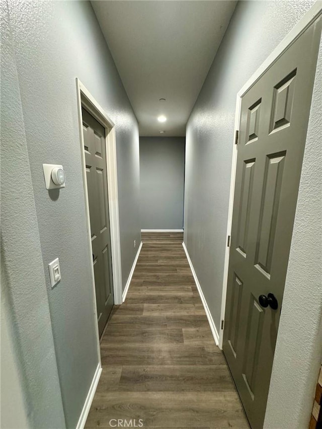 corridor with dark hardwood / wood-style flooring