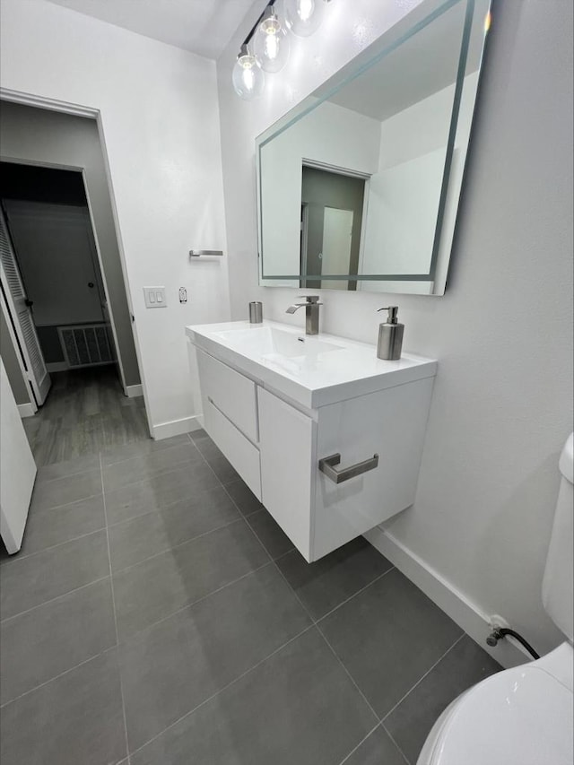 bathroom with vanity, toilet, and tile patterned floors