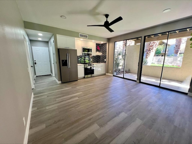 unfurnished living room featuring ceiling fan and wood-type flooring