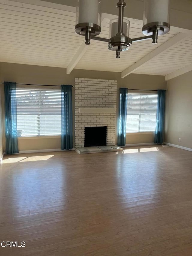 unfurnished living room featuring hardwood / wood-style floors, beam ceiling, and a fireplace