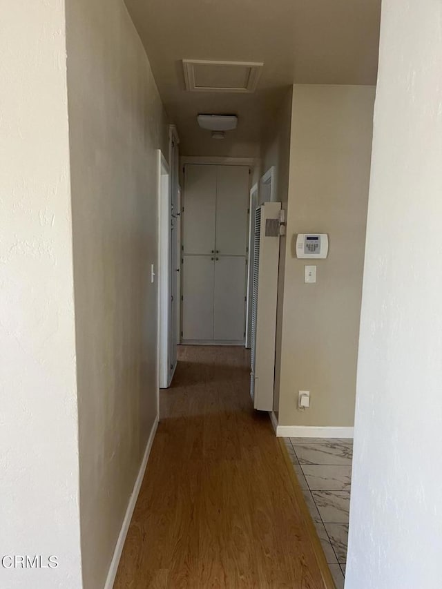 corridor with hardwood / wood-style flooring