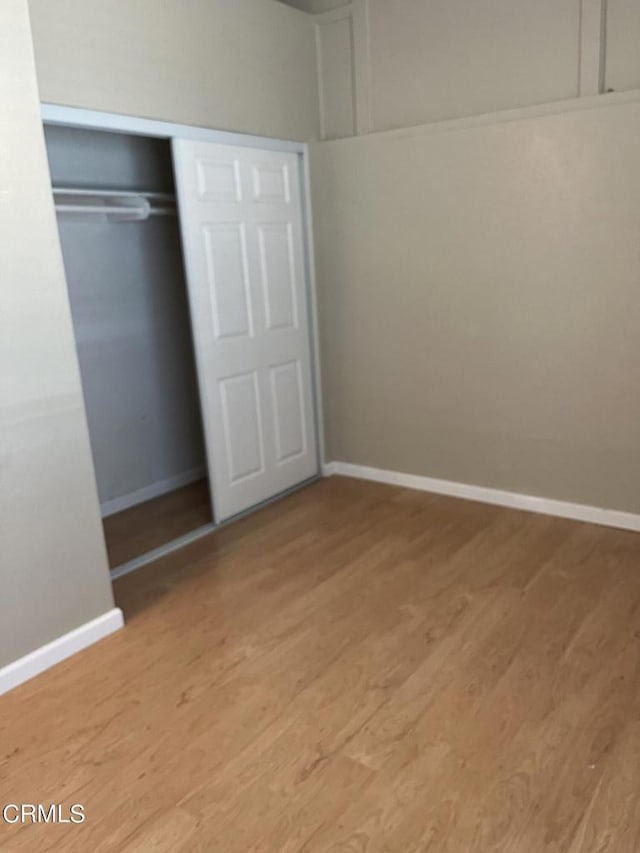 unfurnished bedroom featuring light wood-type flooring and a closet