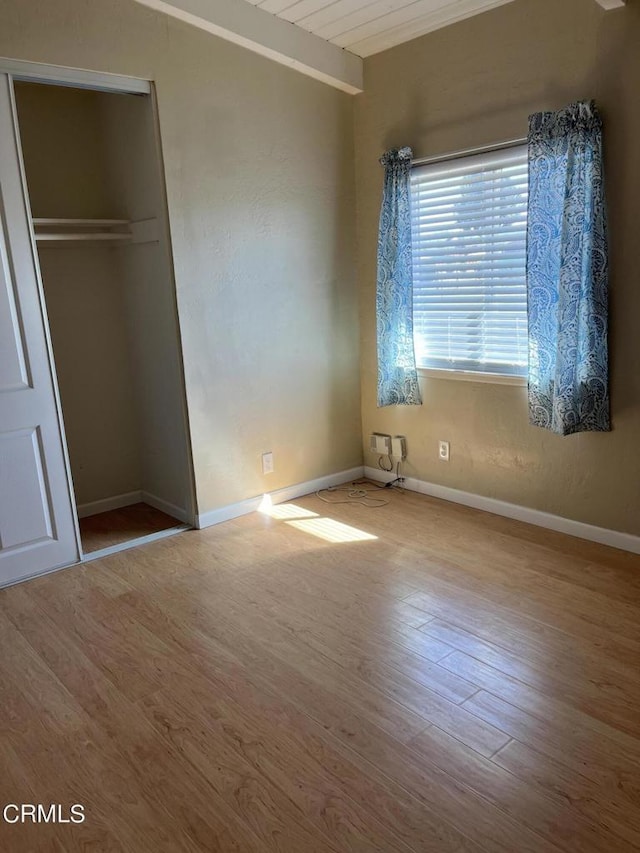 unfurnished bedroom featuring wood-type flooring and a closet