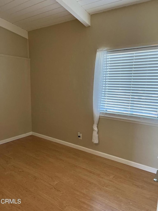 empty room with hardwood / wood-style flooring, lofted ceiling with beams, and wood ceiling