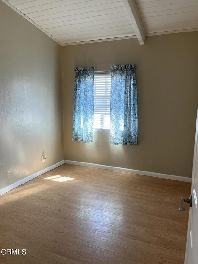 spare room featuring lofted ceiling with beams, hardwood / wood-style floors, and wood ceiling