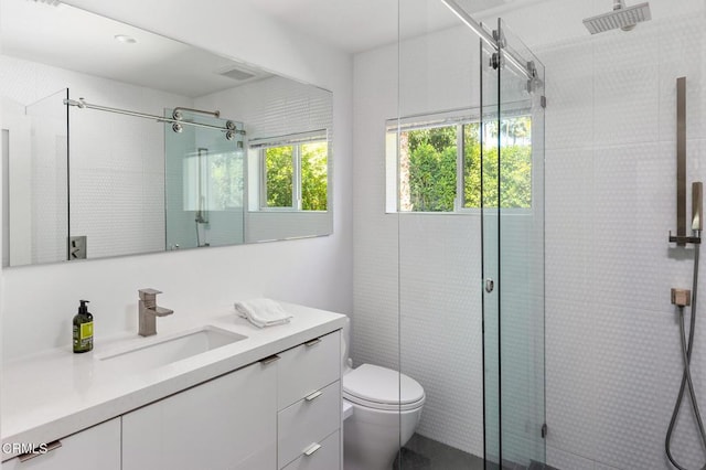 bathroom featuring vanity, toilet, and a shower with shower door