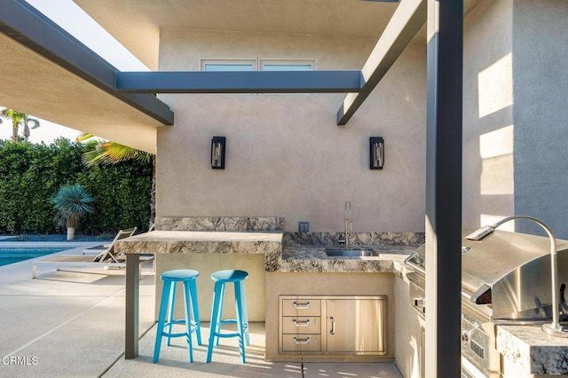 view of patio featuring exterior kitchen and an outdoor wet bar