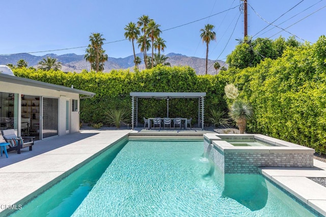 view of swimming pool with a patio area, an in ground hot tub, and a mountain view