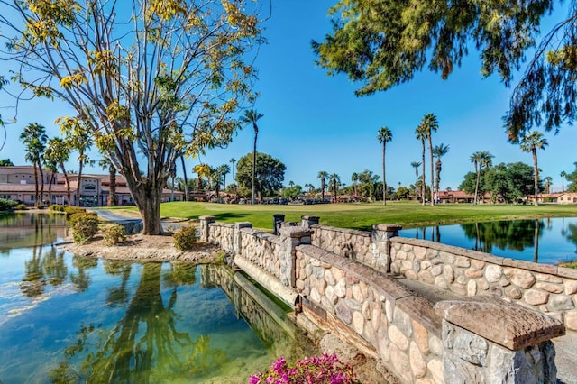 view of home's community featuring a lawn and a water view