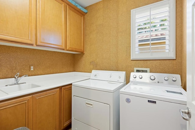 laundry area featuring cabinets, independent washer and dryer, and sink