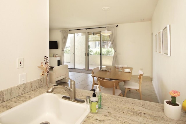 interior space with light tile patterned flooring, pendant lighting, and sink