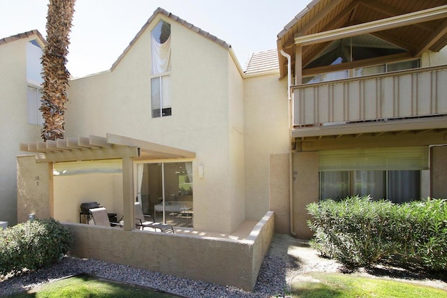 back of house with a pergola, a balcony, and a patio area