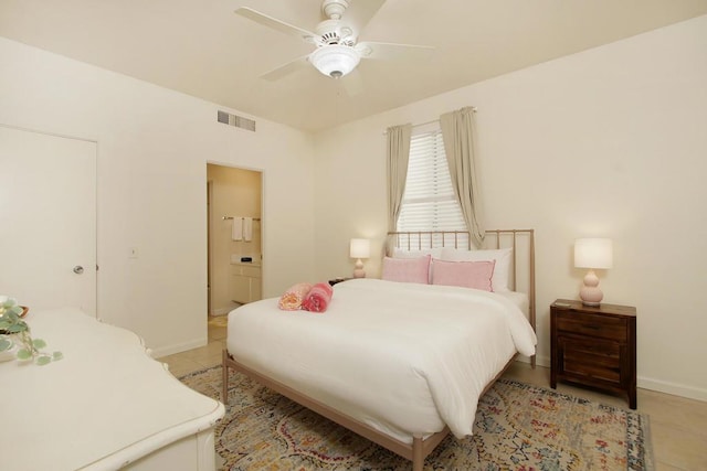 tiled bedroom featuring ceiling fan and connected bathroom