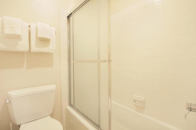 bathroom featuring enclosed tub / shower combo and toilet