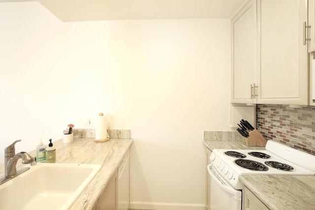 kitchen featuring white electric range, sink, light stone countertops, tasteful backsplash, and white cabinetry