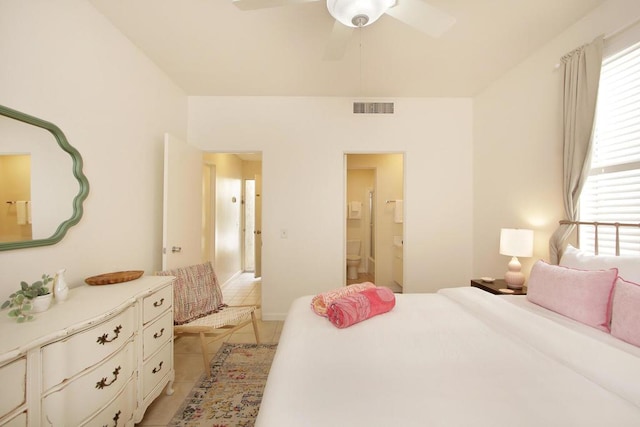 bedroom with ceiling fan, light tile patterned floors, and ensuite bath