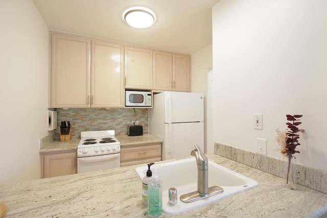 kitchen featuring decorative backsplash, sink, and white appliances