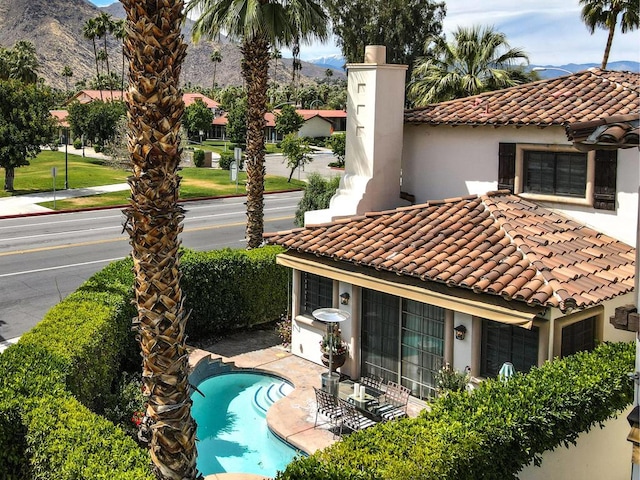 rear view of property with a mountain view and a patio area